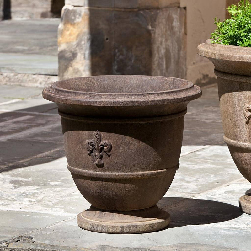 Campania International Fleur de Lis Small Urn is shown in the Pietra Nuovo Patina. Made from cast stone.