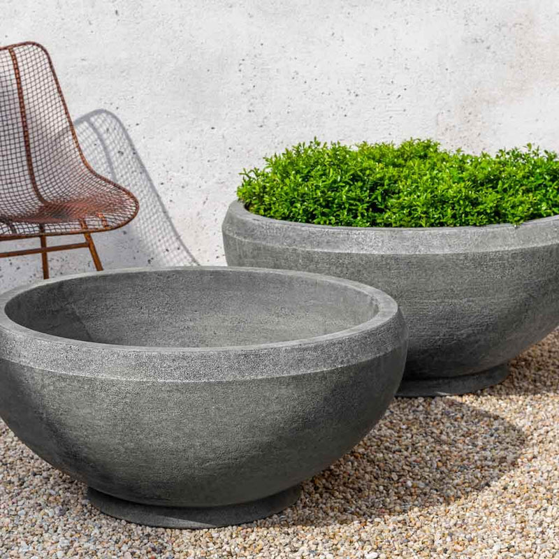 Campania International Giulia XL Planter is patio perfection planted with soft foliage and shown in the Alpine Stone Patina. Made from cast stone.