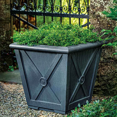 Campania International Directoire Extra Small Planter, filled with soft foliage, ideal for entryways or patios, shown in the Lead Antique Patina. Made from cast stone.