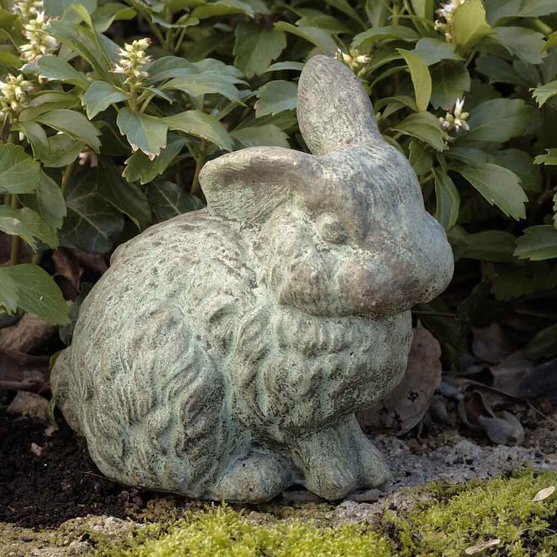 Campania International Rabbit with One Ear Up Statue, set in the garden to add charm and character. The statue is shown in the Copper Bronze Patina.