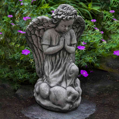 Campania International Angel's Prayer Statue placed in the garden. Religious garden statues, made of cast stone in a range of color options.