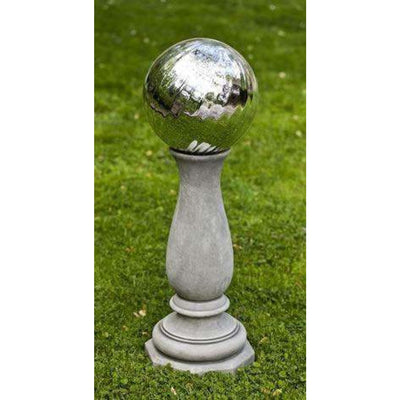 Campania International Winslet Globe Holder, set in the garden elevate a statue or planter. The pedestal is shown in the Greystone Patina.