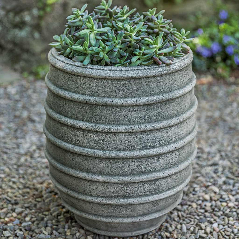 Campania International Tenerife Planter is a small urn with a bold look, filled with succulents and shown in the Alpine Stone Patina. Made from cast stone.