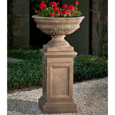 Campania International Coachhouse Urn on Coachhouse Pedestal is shown in the Age Limestone Patina. Made from cast stone.