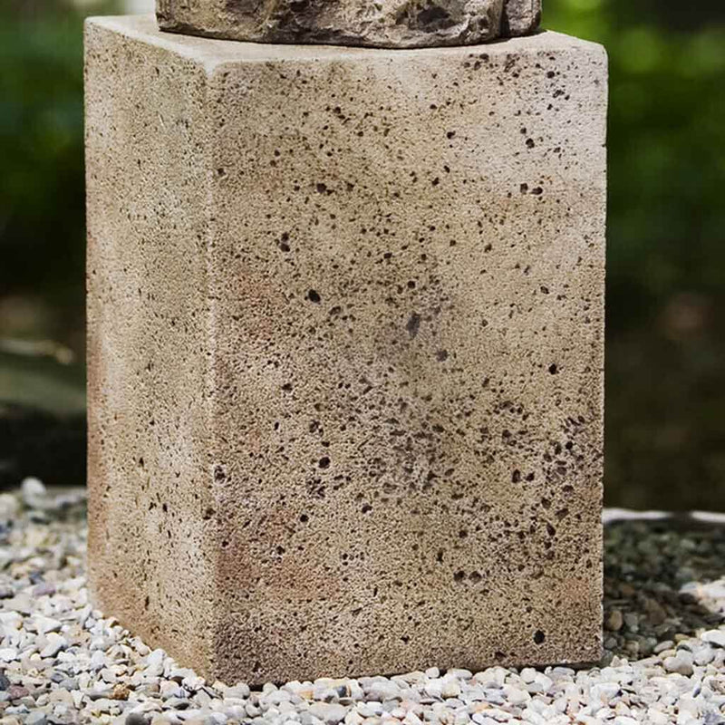 Campania International Medium Art Pedestal, set in the garden elevate a statue or planter. The pedestal is shown in the Alpine Stone Patina.