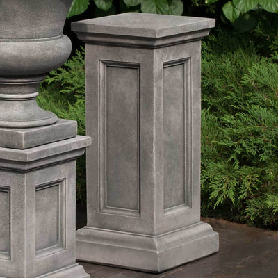 Campania International Lenox Tall Pedestal, set in the garden elevate a statue or planter. The pedestal is shown in the Alpine Stone Patina.