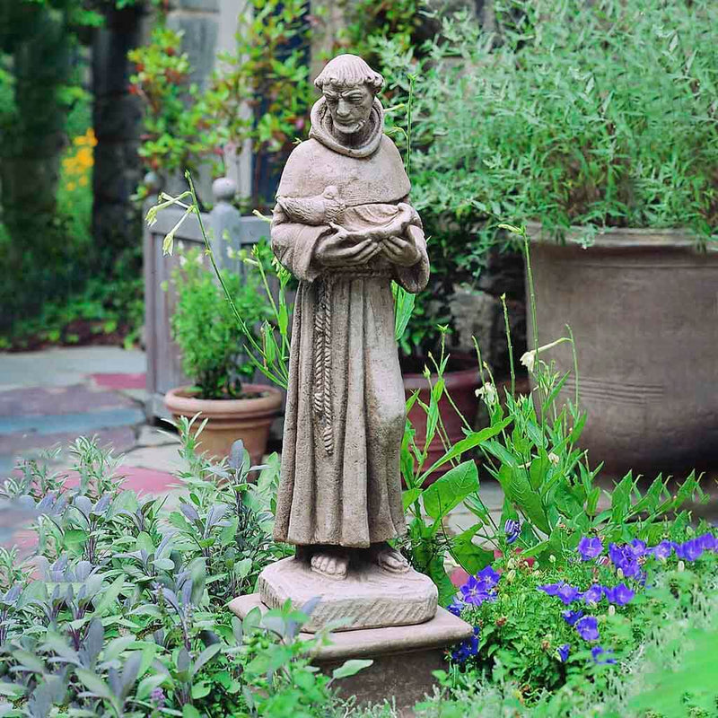 Campania International St. Francis with Shell Statue placed in the garden. Religious garden statues, made of cast stone in a range of color options.