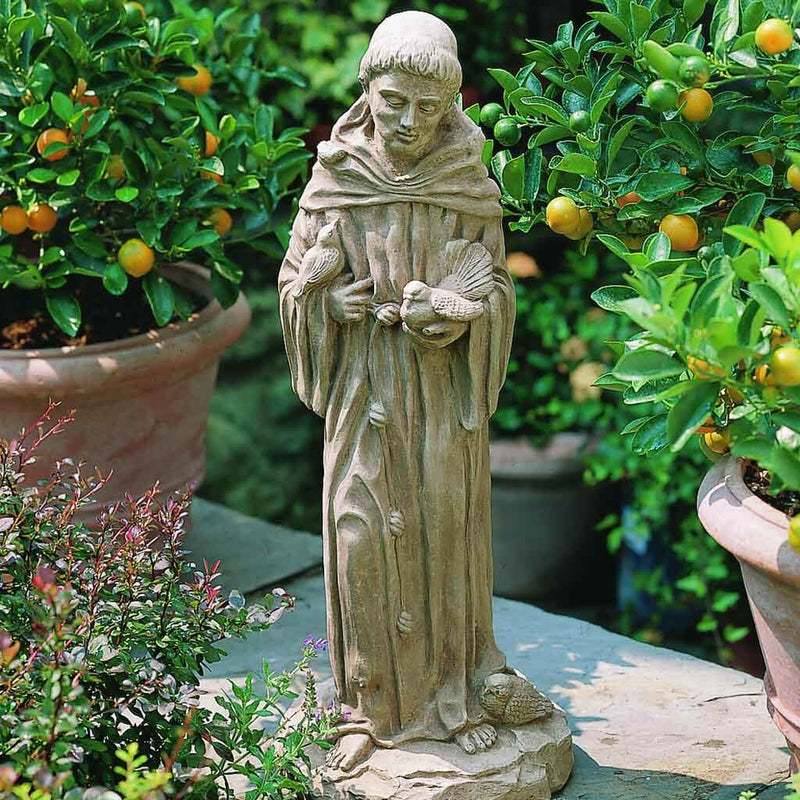 Campania International 25 inch St. Francis Statue placed in the garden. Religious garden statues, made of cast stone in a range of color options.