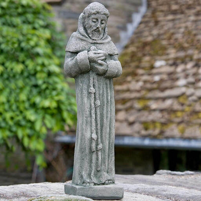 Campania International 14 inch St. Francis Statue placed in the garden. Religious garden statues, made of cast stone in a range of color options.