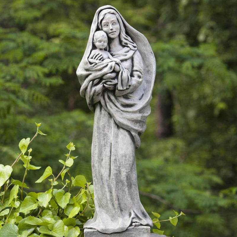 Campania International Standing Madonna and Child Statue placed in the garden. Religious garden statues, made of cast stone in a range of color options.