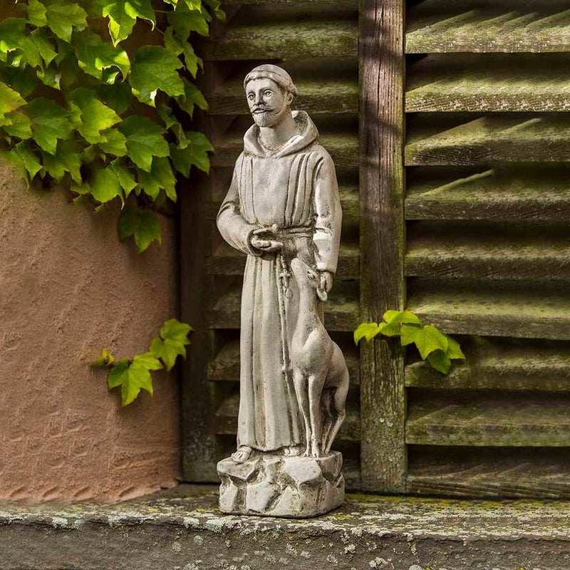 Campania International Small St. Francis with Animals Statue placed in the garden. Religious garden statues, made of cast stone in a range of color options.