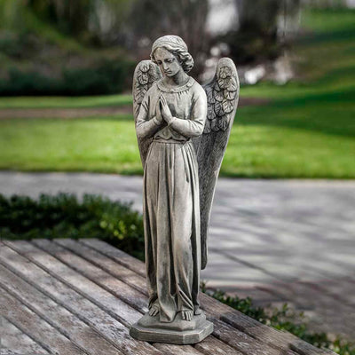 Campania International Angel of Hope Statue placed in the garden. Religious garden statues, made of cast stone in a range of color options.