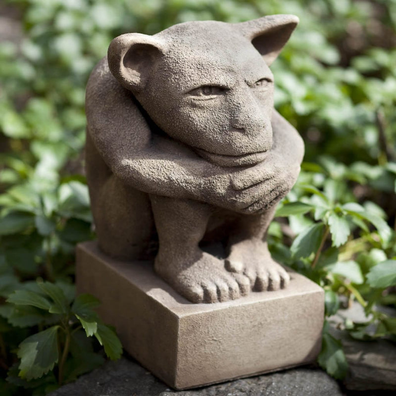 Campania International Sitting Gargoyle Statue, set in the garden to add charm and character. The statue is shown in the Brownstone Patina.